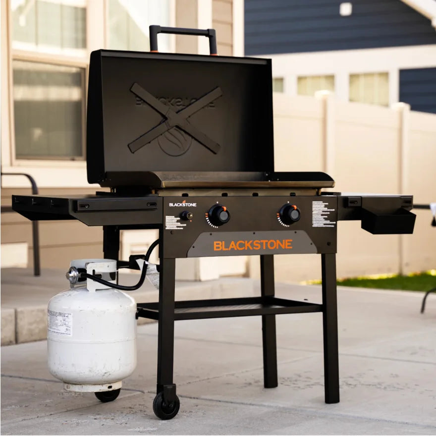 Blackstone Original 28-Inch Griddle with Hood features Omnivore Griddle Plate Technology for even heat distribution and built-in wind guards, along with dual heat zones and a reinforced hood for surface protection and added durability.