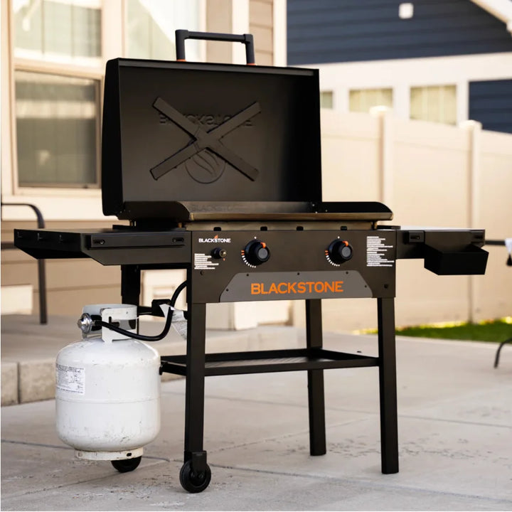Blackstone Original 28-Inch Griddle with Hood features Omnivore Griddle Plate Technology for even heat distribution and built-in wind guards, along with dual heat zones and a reinforced hood for surface protection and added durability.