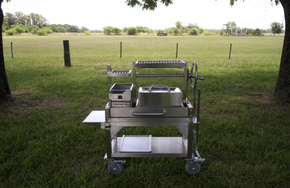 Tagwood Freestanding "Mini" Santa Maria Style Grill: A compact stainless steel grill featuring four cooking zones, interchangeable griddle, and gaucho-style brasero firebox for authentic outdoor cooking experience in small spaces.