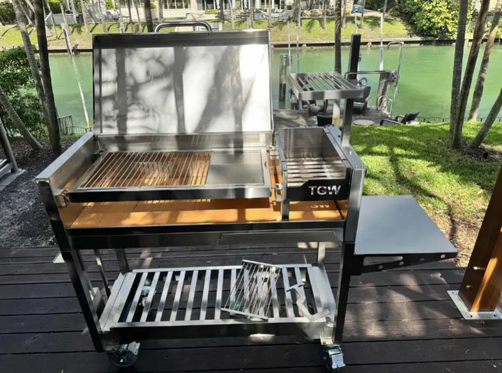 Tagwood Freestanding Santa Maria Style Grill – Stainless Steel with premium 304 stainless steel construction, over 700 sq. in. cooking space, dual preset grate positions, and brasero firebox for authentic Argentine-style live-fire cooking.