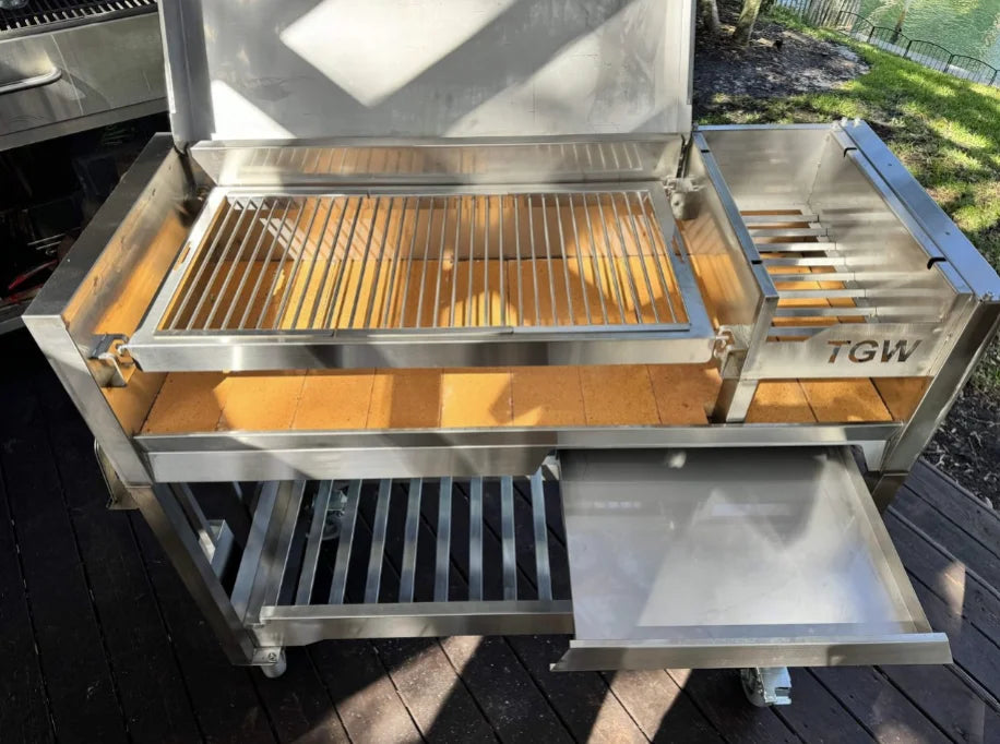 Tagwood Freestanding Santa Maria Style Grill – Stainless Steel, premium 304 stainless steel construction, 705 sq. in. cooking surface, dual preset grate positions, brasero firebox for temperature control.