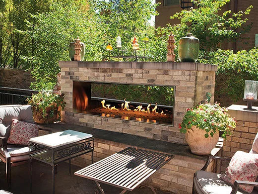 The Carol Rose Collection 48" See-Through Fireplace, featuring a double-sided design with integrated LED lighting and concealed linear burner beneath Clear Frost crushed fire glass for a sleek look day or night.