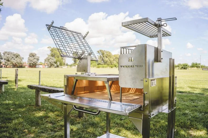 Tagwood Santa Maria Style Clamp Grill with Firebox - #304 stainless steel construction features rotating clamp grill for 360° gaucho-style roasting, fixed grill box, and secondary grate, with firebrick-lined walls ensuring even heat distribution and long-lasting reliability.