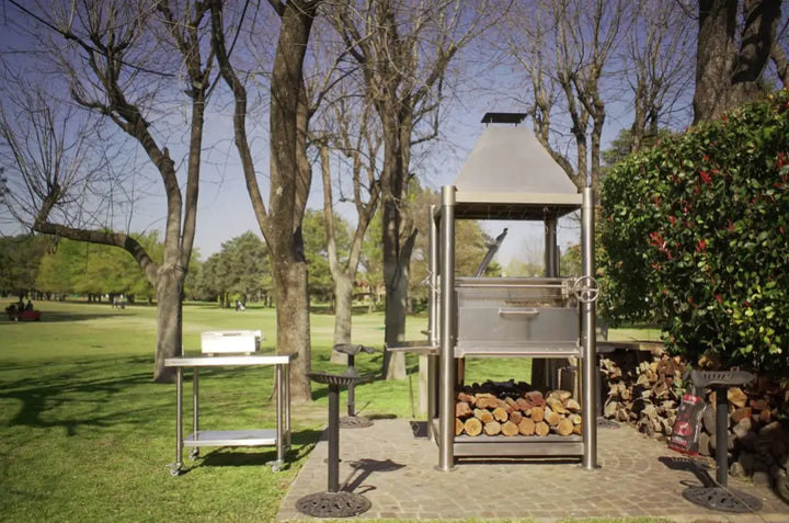 Tagwood "The Silver Bullet" Santa Maria Style Grill - Stainless Steel, featuring six cooking surfaces, built-in firebox, and 304 stainless steel construction for maximum durability in any weather condition.