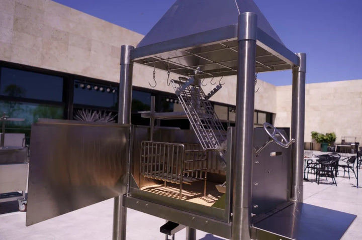 Tagwood "The Silver Bullet" Santa Maria Style Grill - Stainless Steel: High-performance stainless steel grill with six cooking surfaces, 1,700 sq. in. total grilling area, and height-adjustable systems for authentic open-fire experience.