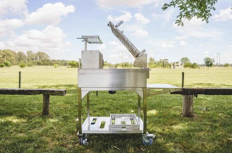 Tagwood Santa Maria Style Clamp Grill with Firebox: #304 stainless steel freestanding grill with rotating clamp grill, fixed grill box, secondary grate, firebrick-lined walls, and integrated firebox for 360° open-fire cooking experience.