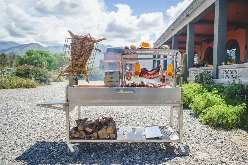 Tagwood XL Freestanding Argentine Santa Maria Style Grill, #304 stainless steel construction, 2,600 sq.in. grilling space across five zones, featuring brasero firebox, firebrick-lined walls, foldable side table and heavy-duty casters.