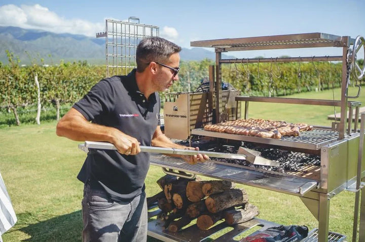 Tagwood XL Freestanding Argentine Santa Maria Style Grill featuring five distinct cooking zones, including main adjustable grate, secondary grate, clamp grill, griddle, and roofing grill.