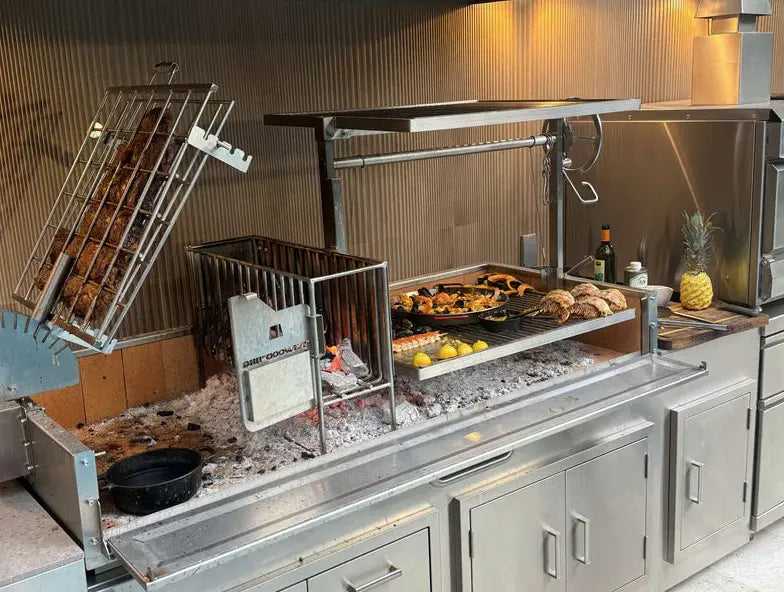 Tagwood 2XL Built-In Santa Maria Style Grill features five cooking zones, including clamp grill, griddle, roofing grill, fixed grate, and secondary grate, for over 2,600 sq. in. of grilling space across premium 304 stainless steel construction with integrated firebox brasero and firebrick-lined panels for efficient heat retention and durability.