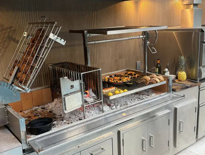 Tagwood 2XL Built-In Santa Maria Style Grill features five cooking zones, including clamp grill, griddle, roofing grill, fixed grate, and secondary grate, for over 2,600 sq. in. of grilling space across premium 304 stainless steel construction with integrated firebox brasero and firebrick-lined panels for efficient heat retention and durability.