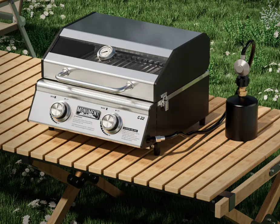 Monument Grills "G22" Tabletop Gas Grill - compact stainless steel grill designed for small spaces, delivering 15,000 BTUs of total heat output across two powerful burners, with 207 sq. in. of cooking space and portable design for patios, balconies, RV setups, or campsite tables.
