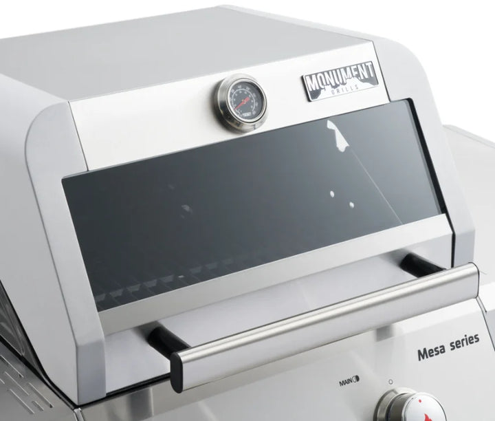 Monument Grills Mesa Series M200S Compact Stainless Steel Propane Gas Grill for Small Spaces, featuring two 15,000 BTU burners, porcelain-coated cast iron cooking grates, and an easy-to-assemble design.
