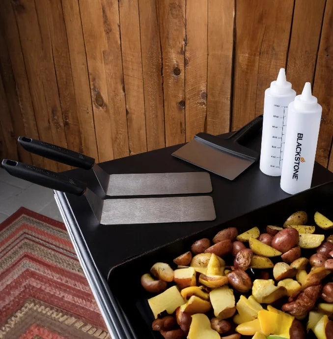 Blackstone 5 Piece Professional Griddle Toolkit featuring two long stainless-steel spatulas for flipping and serving, a beveled edge griddle scraper, and two 16 oz. squeeze bottles for sauces and oils.