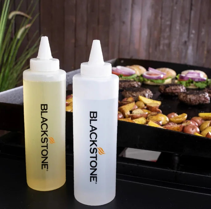 Blackstone 5 Piece Professional Griddle Toolkit featuring two long stainless-steel spatulas, beveled edge griddle scraper, and two 16 oz. squeeze bottles for effortless cooking.