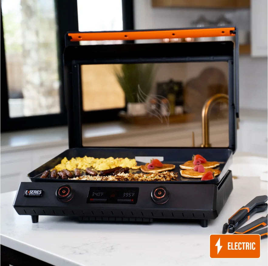 Blackstone E-Series 22-Inch Electric Tabletop Griddle featuring 312 sq. in. ceramic titanium-coated cooking surface with dual independently controlled heat zones and removable teppanyaki-style hood for versatile indoor or outdoor griddle cooking.
