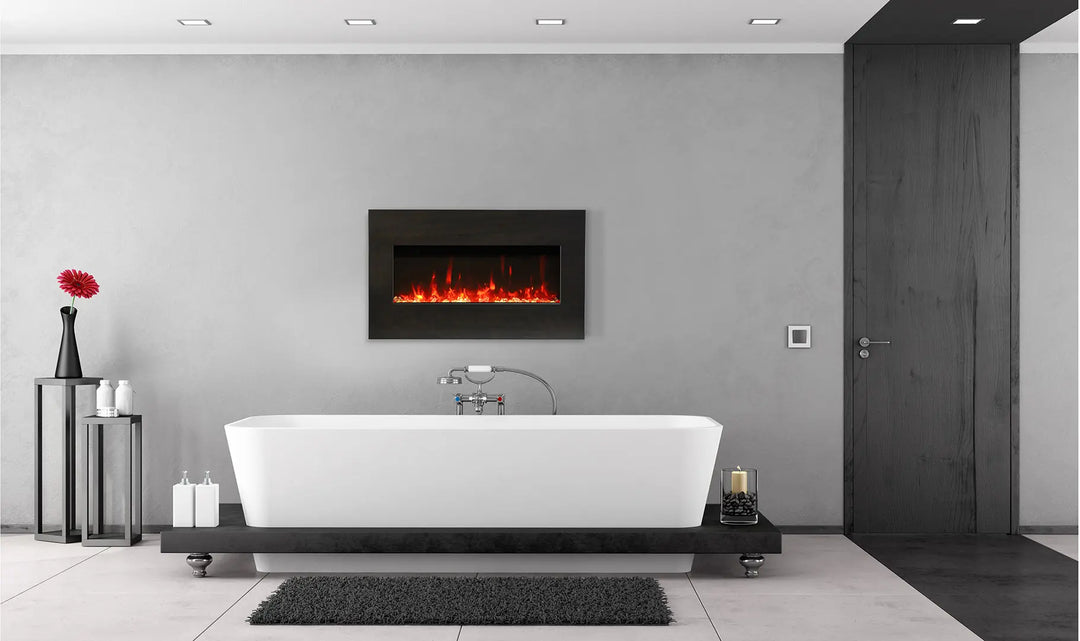 Amantii Panorama BI Extra Slim Smart Electric Fireplace: Sleek black steel surround encases clear glass media in this ultra-slim (4” deep) indoor/outdoor electric fireplace, perfect for installations with limited wall depth, featuring vibrant multi-colored flame presentation and remote control.
