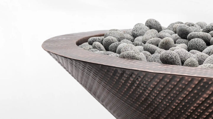 The Outdoor Plus Cazo Copper Fire Bowl, crafted from durable solid copper with a hand-applied hammered patina finish, features a tapered bowl shape and reflective finish for upscale outdoor spaces.