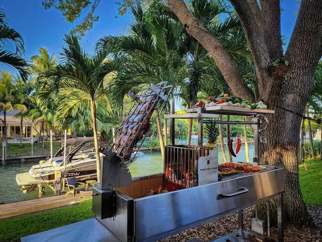 Tagwood Freestanding Santa Maria Style Grill featuring 304 stainless steel construction, 5 cooking surfaces, 360° rotating clamp grill, firebrick-lined walls, and adjustable main grate.