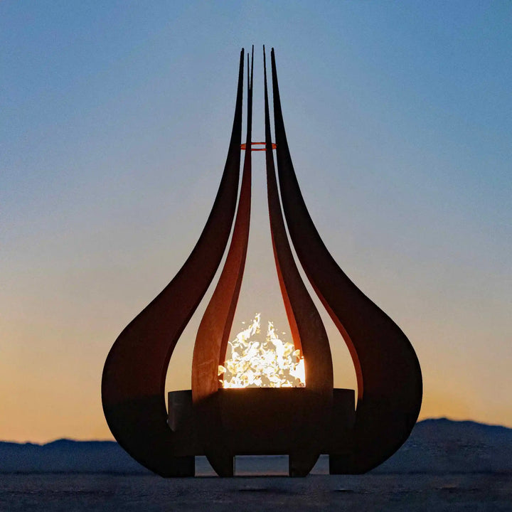 Dramatic Comet Fire Sculpture - The Outdoor Plus features curved panels framing a warm, glowing flame at its center, adding light and style to patios and gardens.