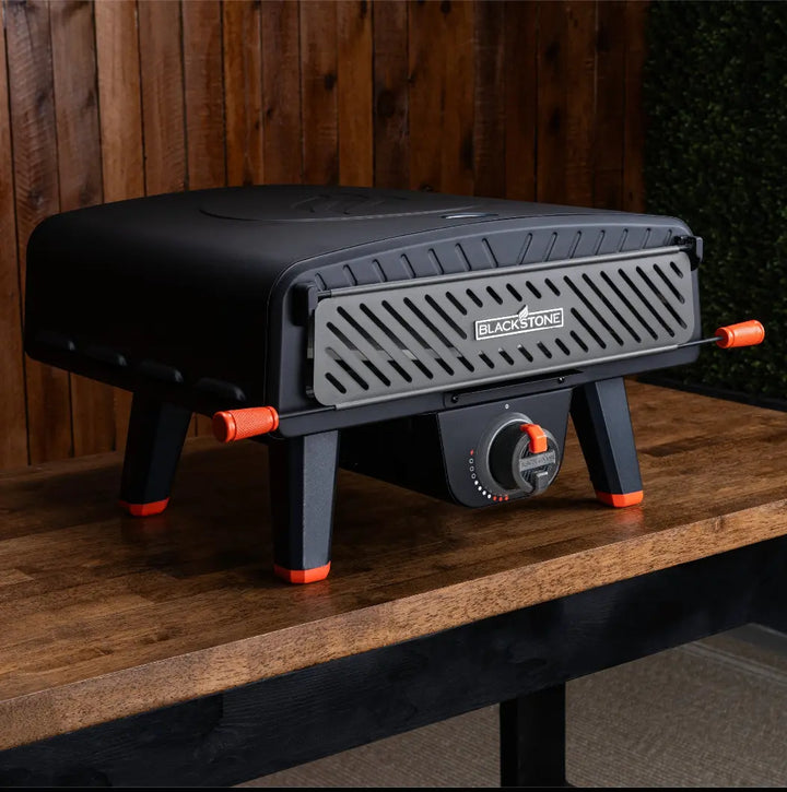 Blackstone Leggero Pizza Oven features a 13" rotating cordierite stone for effortless pizza turning, powered by a propane burner that heats from below and retains heat with its door.