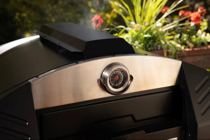 Blackstone Portable Pizza Oven Bundle features patented 2-Stone Technology for even heat distribution, includes bonus accessories like pizza peel and rocker cutter, perfect for cooking up to 15-inch pizzas outdoors.