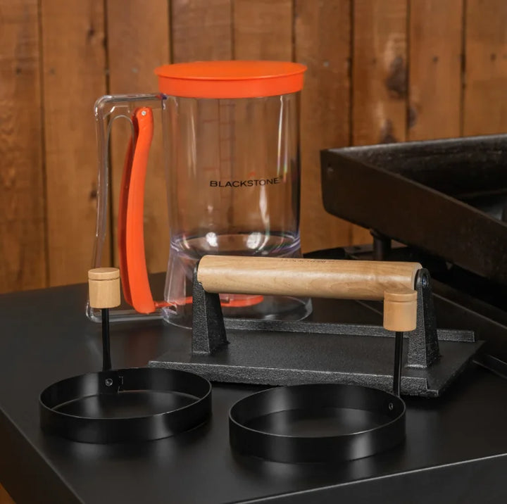 Blackstone Breakfast Kit featuring a pre-seasoned cast iron bacon press, easy-to-use batter dispenser holding up to 4 cups, and perfectly round egg rings for uniform eggs or pancakes.