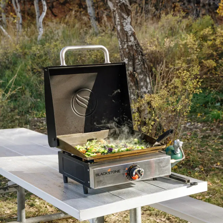 Blackstone Original 17” Blackout Omnivore Tabletop Stainless Griddle w/Hood: compact stainless steel griddle with advanced Omnivore Technology for fast heat-up and even cooking, built-in hood and wind guards for optimal performance.
