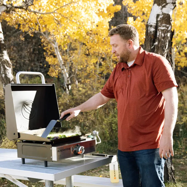 Blackstone Original 17" Blackout Omnivore Tabletop Stainless Steel Griddle with Built-in Hood, featuring a compact design, one heat zone, and built-in hood for outdoor cooking adventures.