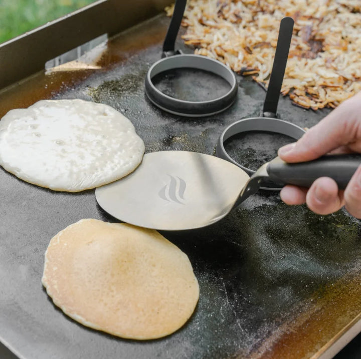 Blackstone Griddle Essentials Breakfast Kit (4 pc) featuring a round spatula, stir and pour batter mixer, crepe spreader, and 2-section egg ring tray for precision cooking of pancakes, eggs, and more.
