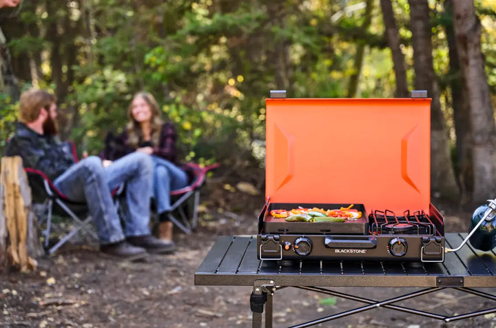 Blackstone OTG 14” Griddle with Side Burner: A compact, travel-ready camping cooking unit featuring an independently controlled griddle and side burner, coated non-stick plate, and leveling feet for easy cooking on uneven terrain.