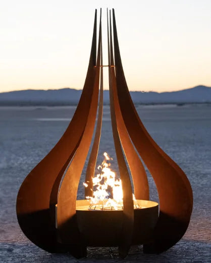 Dramatic Comet Fire Sculpture - The Outdoor Plus, featuring curved Corten steel panels framing a warm, glowing flame in an artistic, flame-like design for outdoor spaces.