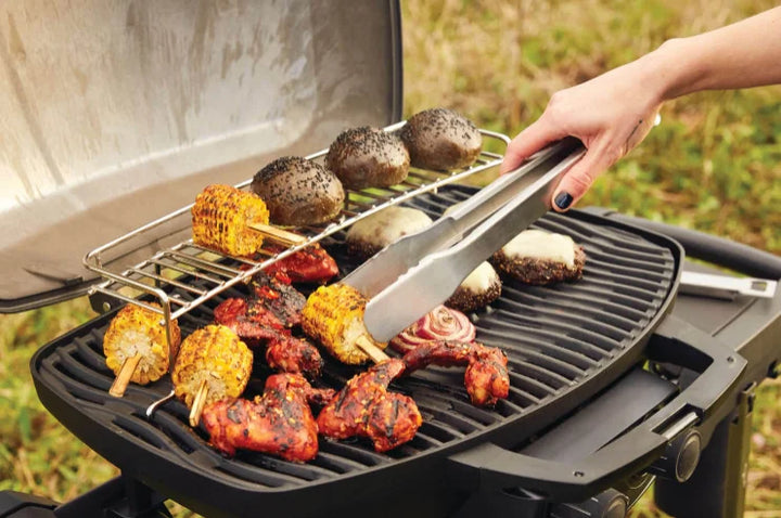 Napoleon Phantom TravelQ PRO 285 portable gas grill features sleek matte black finish, high-top lid, stainless steel burners, removable warming rack, and scissor cart for effortless transport.