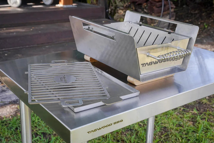 Table Top Warming Brazier made from premium 304 stainless steel with acacia wood accents, features a spacious 121 sq. in. warming surface and includes two skewers for versatile use.