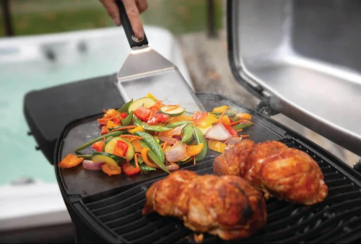 Napoleon TravelQ Pro285E Portable Electric Grill features sleek all-black design, refined chrome accents, and high-topped cast aluminum lid for windproof heat retention and restaurant-quality results.