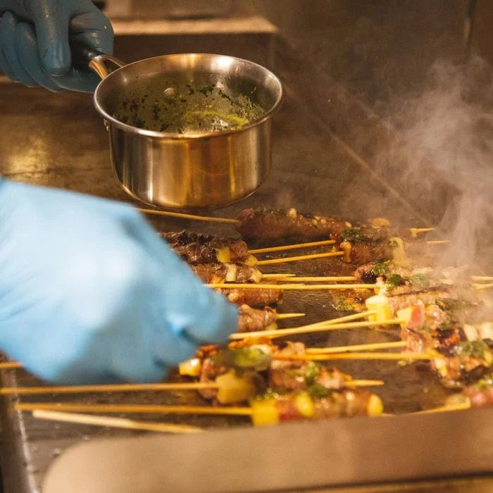 The Grand Texan Gas Built-In 60" Griddle with Lid by Le Griddle features two expansive stainless steel griddle plates, four powerful U-shaped burners producing 36,000 BTUs, and a durable cast iron base for consistent heat distribution.