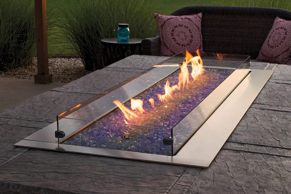 The Carol Rose Collection 48" LED Linear Outdoor Firepit features sleek stainless steel design, powerful 55,000 BTUs heat output, and customizable LED lighting for a dramatic centerpiece in any outdoor gathering setting.