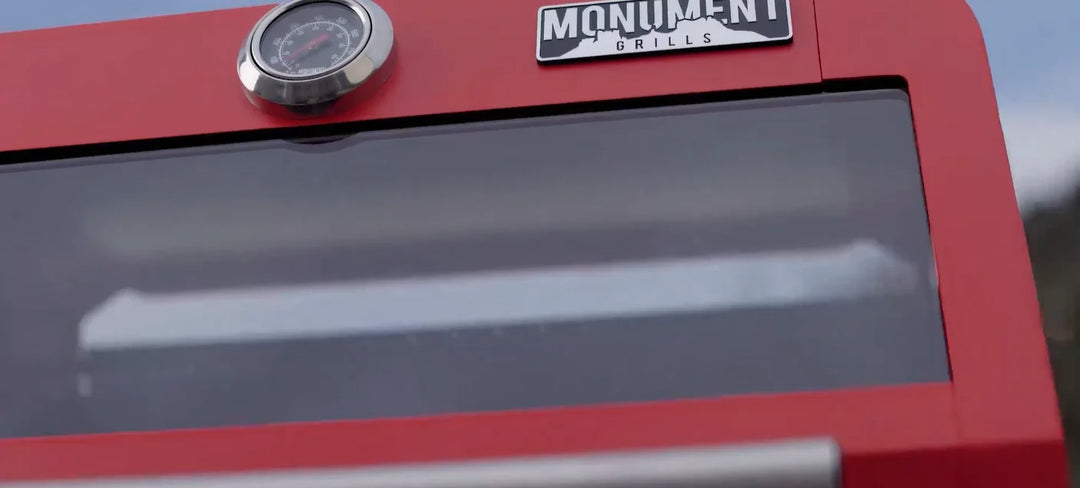 Monument Grills "M200S" Red Gas Grill - Mesa Series Heartbeats Edition: A compact, 2-burner red powder-coated propane gas grill featuring 30,000 BTUs of total cooking power with porcelain-coated cast iron grates and a modern, rounded corner design for effortless maintenance.