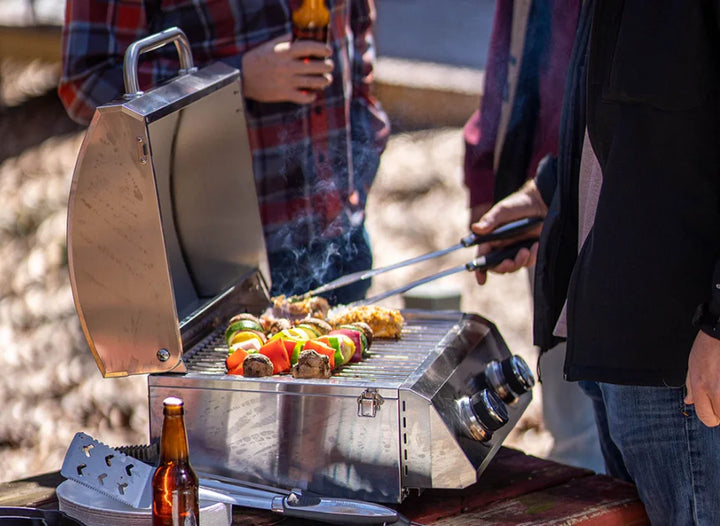 Monument Grills 13742 2-Burner Tabletop Gas Grill - Classic Series: A compact, portable stainless steel grill for outdoor use, featuring two burners producing 15,000 total BTUs and 207 sq. in. of cooking space.